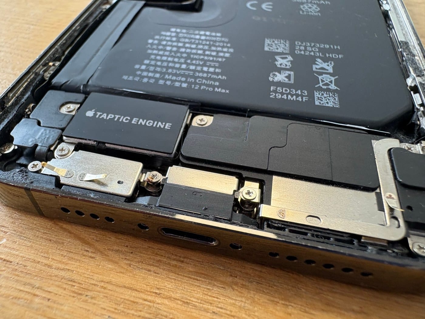 Geöffnetes iPhone mit sichtbarem Akku im Inneren