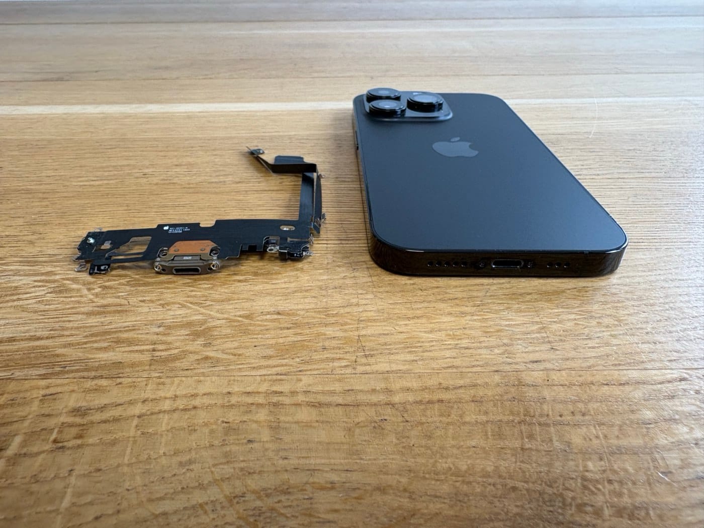 Ausgebaute iPhone-Ladebuchse mit Flexkabel in unserer Werkstatt